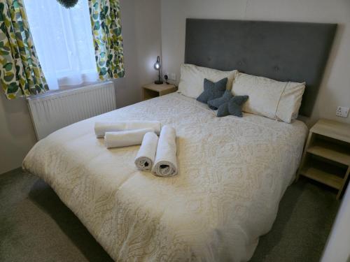 a bedroom with a white bed with towels on it at Baywood View Lodge in East Heslerton