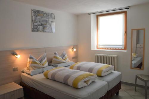 een slaapkamer met twee bedden met kussens erop bij Chalet Aura in Livigno