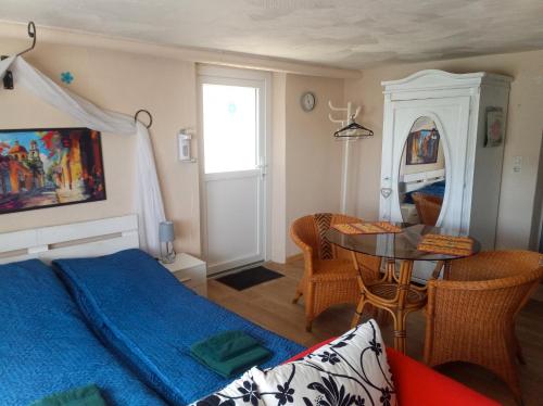 a bedroom with a blue bed and a table at Kleines Burgstübchen in Hundheim