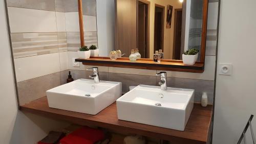 a bathroom with two white sinks and a mirror at Gite Du Berger Paris Climatisé in Coustaussa