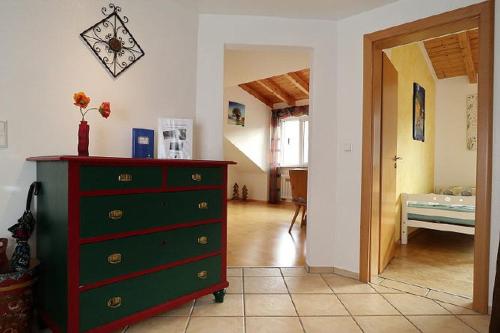 ein Wohnzimmer mit grüner Kommode und ein Schlafzimmer in der Unterkunft Haus Reichenbach in Glottertal