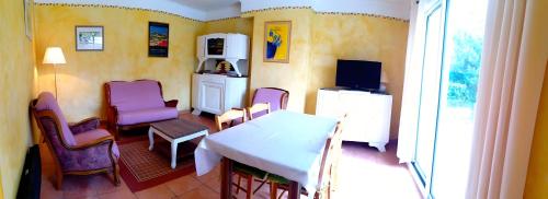 ein Esszimmer mit Tisch und Stühlen und eine Küche in der Unterkunft Le Saule in LʼIsle-sur-la-Sorgue