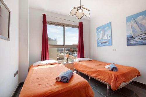 zwei Einzelbetten in einem Zimmer mit Fenster in der Unterkunft Marfolin 22 in Cotillo