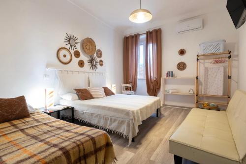 une chambre avec deux lits et un canapé dans l'établissement Domus De Mirto, à Sennori