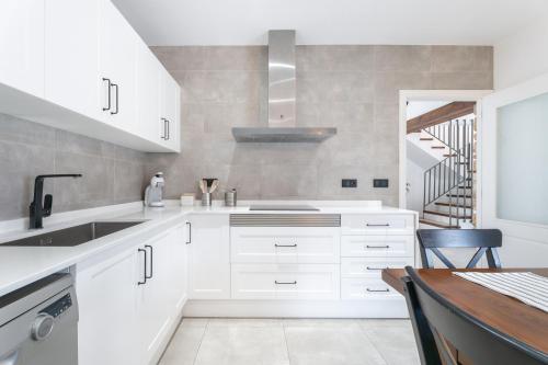 a white kitchen with a sink and a staircase at El Secret De Marco in Vall dʼAlba