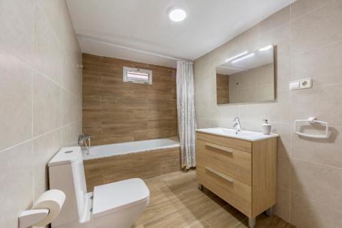 a bathroom with a toilet and a sink and a tub at Noria 2 in Níjar