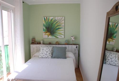 a white bed in a room with a window at El Rinconcito de Rosa ideal parejas in Nerja
