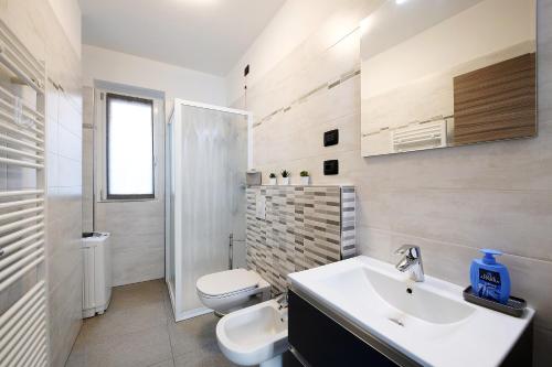 a white bathroom with a sink and a toilet at Appartamento 4 in Nesso