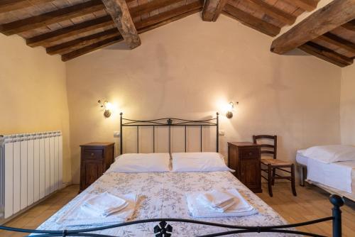 a bedroom with a bed in a room with wooden ceilings at Appartamento Il Colombaio in Corgna