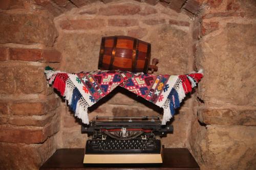 an old fashioned typewriter in a stone room with a blanket at Retro Hostel in Cluj-Napoca