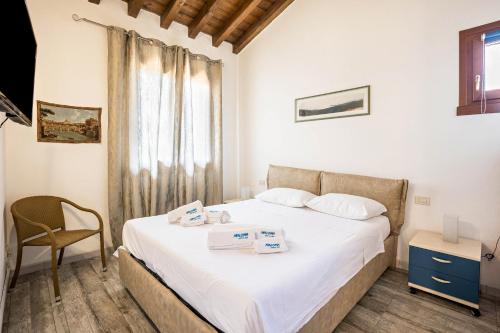 una camera con un letto, una sedia e una finestra di Maloma a Peschiera del Garda