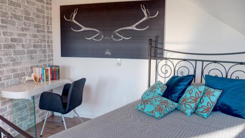 Un dormitorio con una cama con almohadas azules y un escritorio. en Studio Dinkelberg, en Adelhausen