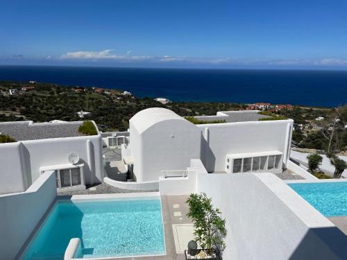 OrgaにあるRomantic Santorini-Style Villa with Private Pool and Sea Viewのスイミングプール付きのヴィラを望めます。