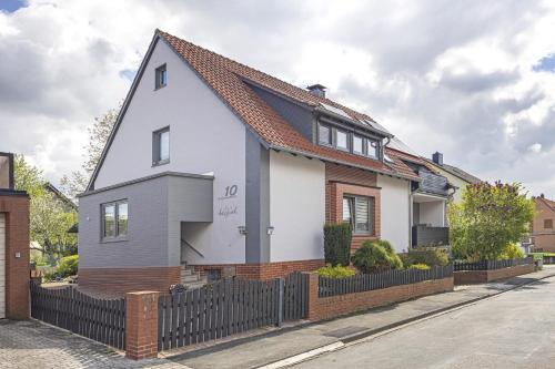 een wit huis met een zwart hek bij Ferienwohnung Harzreich in Seesen