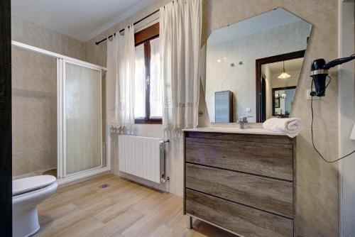 a bathroom with a sink and a toilet and a mirror at Villa Carmen in Ronda