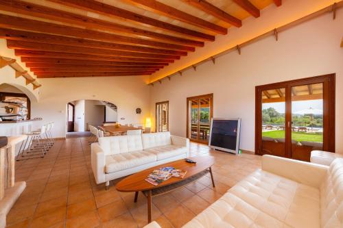 a living room with white couches and a table at Finca Mirador Capdepera in Capdepera