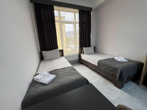 two beds in a room with a window at Loft Inn Ijevan in Ijevan