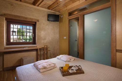 a bedroom with a bed with towels and a window at Neoria Houses in Chania