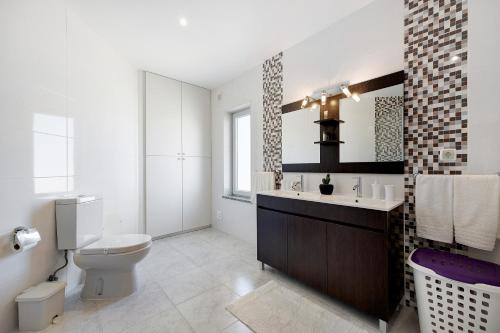 a bathroom with a toilet and a sink and a mirror at Lugar Encantador in Alvor