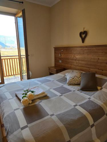 a bedroom with a large bed with a large window at Antico Fienile Agritur in Mezzocorona
