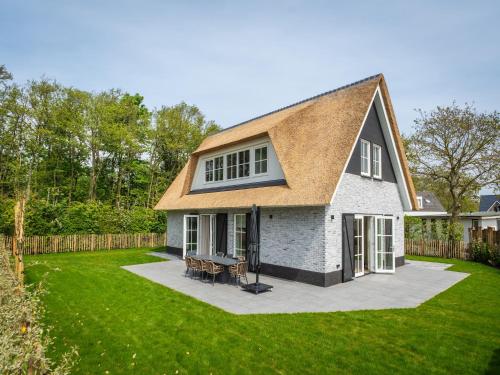 a house with a grass yard with a patio at Pretty Holiday Home in De Koog Texel with Garden in Westermient