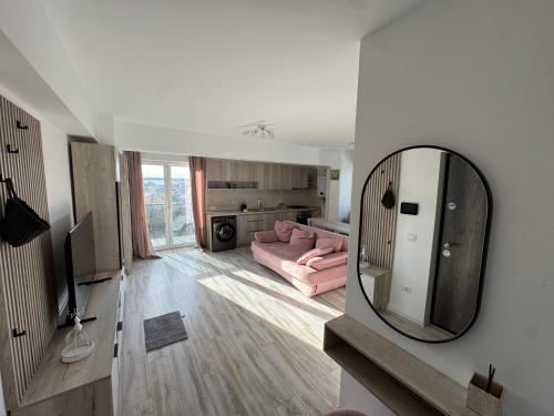 ein Wohnzimmer mit einem rosa Sofa und einem Spiegel in der Unterkunft Staywell University with underground parking in Suceava
