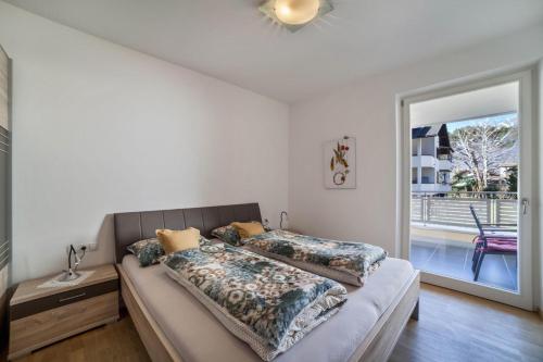 een slaapkamer met een bed en een glazen schuifdeur bij Truma Swing Small And Cozy in Merano