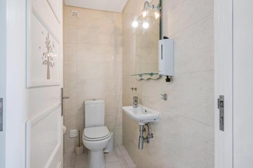 a small bathroom with a toilet and a sink at São Rafael Praia in Albufeira