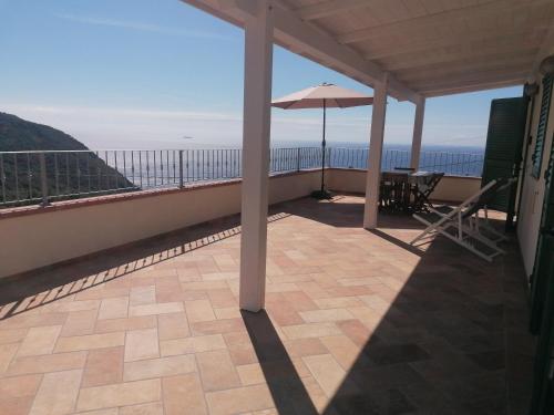 a balcony with an umbrella and a table and chairs at L' Elicriso in Marciana