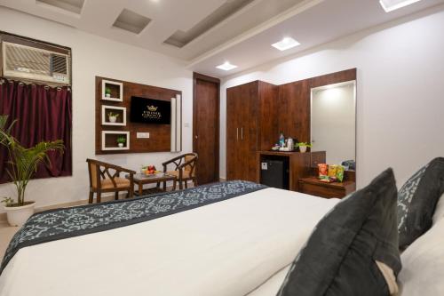 ニューデリーにあるHotel Krone Plaza Near IGI Airportの白いベッドとテーブルのある寝室