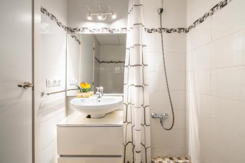 a white bathroom with a sink and a mirror at Fantastic in Can Picafort