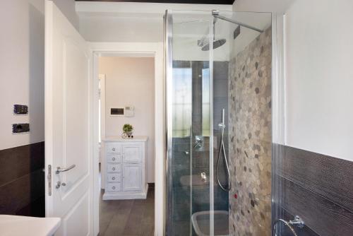 une salle de bain avec une douche avec une porte vitrée dans l'établissement Casa Girasole 600 mt dal mare, à Imperia