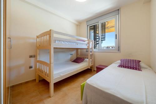 ミアミ・プラトーヤにあるMar de Lauraの二段ベッド2台と窓のある寝室