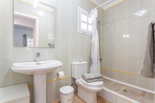 a white bathroom with a sink and a toilet at Casa vista golf in Caleta De Fuste
