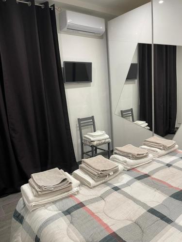 a room with three beds with a mirror and a table at La Divina Holiday in Ravenna