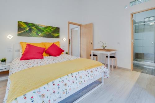 a bedroom with a large bed with red pillows at Estudio Tajinaste in Arona