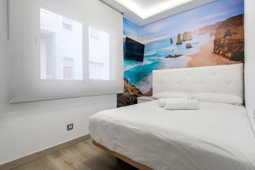 a bedroom with a bed and a painting on the wall at Duplex center- Calafell in Calafell