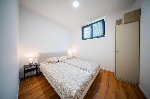 een witte slaapkamer met een bed en een raam bij Flex SelfCheckIns 188 - Zagreb - 2 Bedrooms - Parking in Zagreb