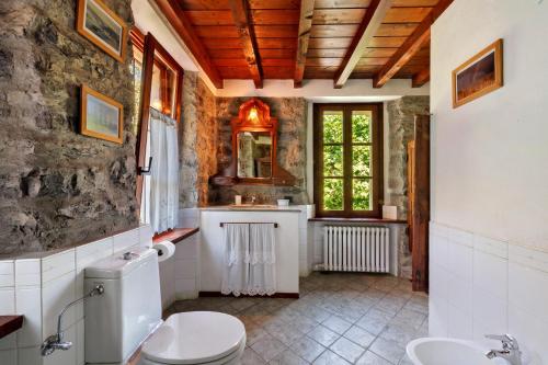 a bathroom with a toilet and a sink at Casale La Selva Cottege grande in Piano Porlezza