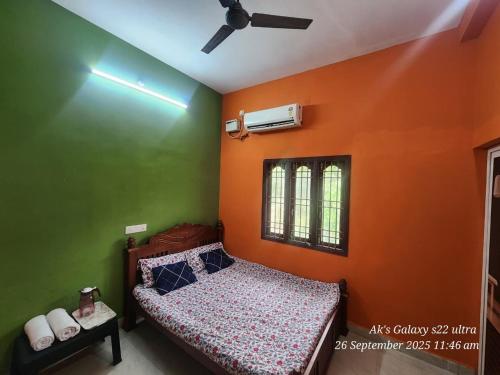 a bedroom with green and orange walls and a bed at Le homestay villa in Puducherry
