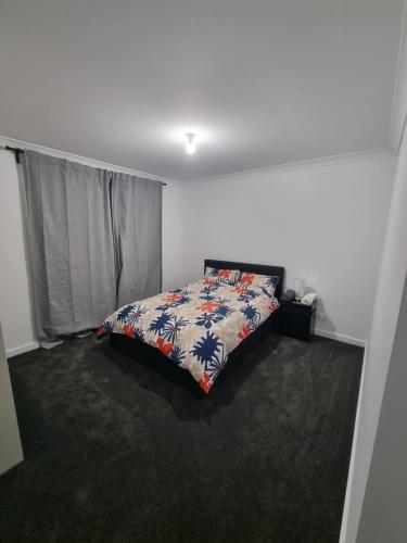 Sutton Town11 Federation Drive的卧室里有一张铺着花卉床罩的床