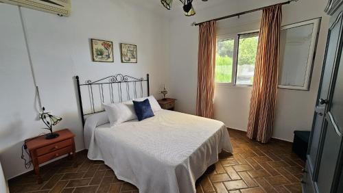 ein Schlafzimmer mit einem Bett und einem Fenster in der Unterkunft Casa Rural The Hope in La Puebla de Cazalla