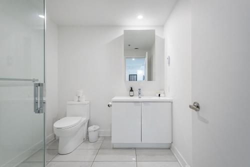 een witte badkamer met toilet en douche bij Downtown Montreal 1BR - Sleeps 4 in Montreal