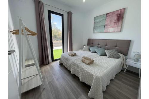 マラガにあるVilla Marietoの大きなベッドと大きな窓のある寝室