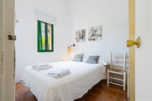 a white bed in a room with a window at Finca Encina - piscina compartida in Alájar