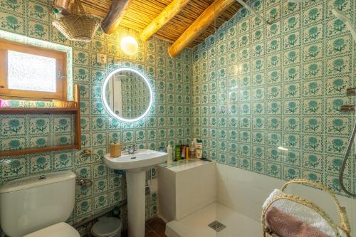 a bathroom with green tiled walls and a toilet and a sink at Zarzamora de Rubite in Rubite
