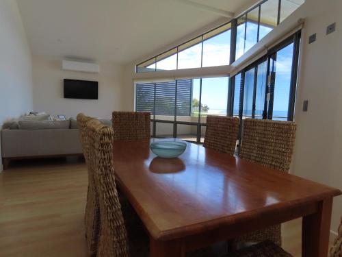a dining room with a wooden table and chairs at Birubi Holiday Homes Kangaroo Island in Emu Bay
