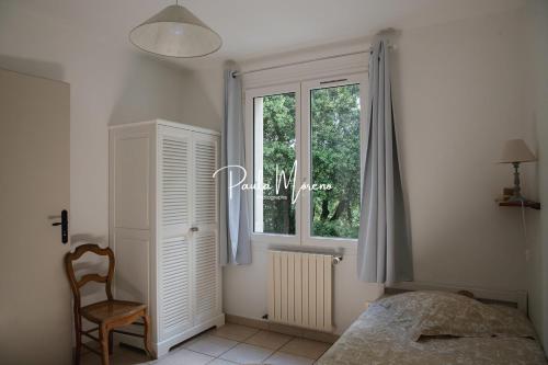 Montbrison-sur-LezにあるGîte Sur Domaine Viticoleのベッドルーム1室(ベッド1台、窓、椅子付)