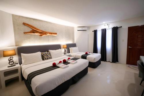 a hotel room with two beds and a couch at El Fuego Boracay in Boracay