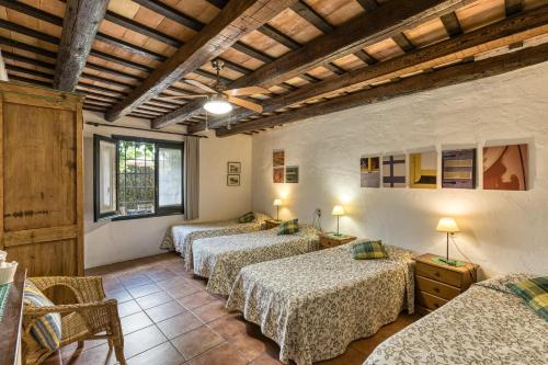 eine Gruppe von 4 Betten in einem Zimmer in der Unterkunft Casa Rural La Pallissa de Llampaies in Llampaies